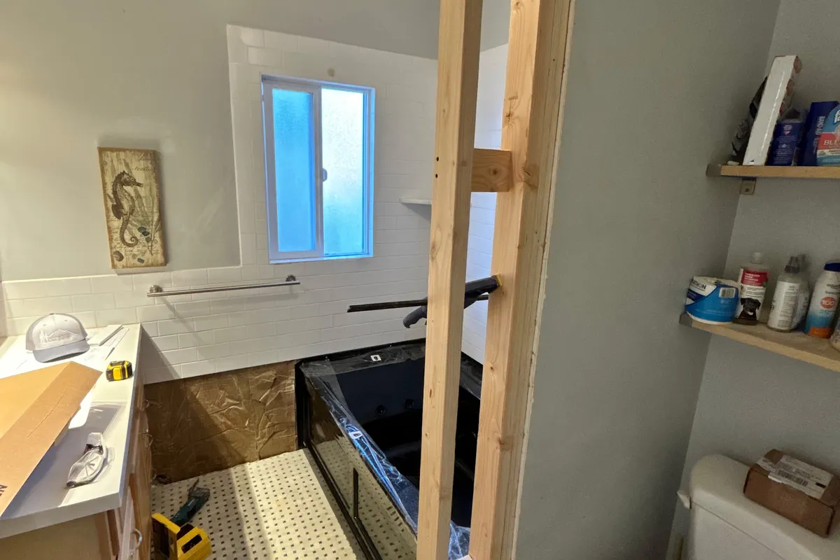 Bathroom remodel with new partition framing and drywall around a tub