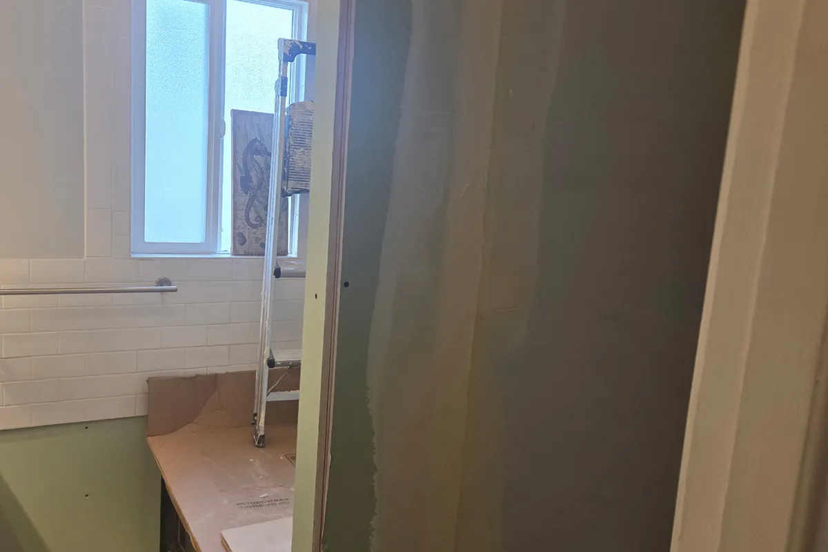 Taped and mudded drywall seam on a bathroom wall during finishing