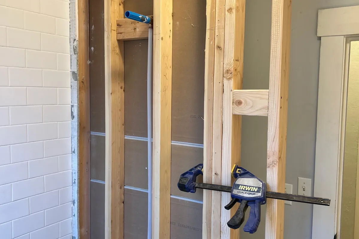 Framed wall with drywall and backer board installed around a shower niche