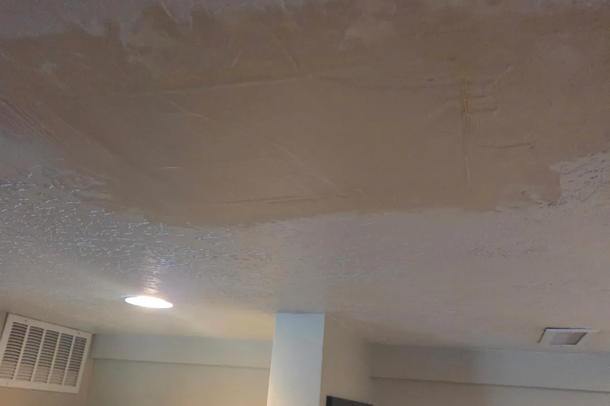 Re-textured ceiling with matched knockdown texture near the HVAC vents